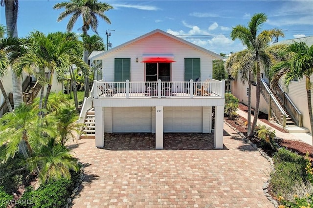 291 Mango St, Fort Myers Beach, FL 33931 - coastal home with stairway, a garage, and decorative driveway