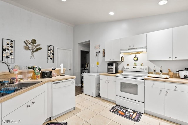 2909 48th St SW, Lehigh Acres, FL 33976 - kitchen featuring white appliances, under cabinet range hood, vaulted ceiling, light tile patterned floors, and light countertops
