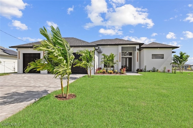 220 NE 6th St, Cape Coral, FL 33909 - prairie-style house with an attached garage, driveway, a front yard, and stucco siding