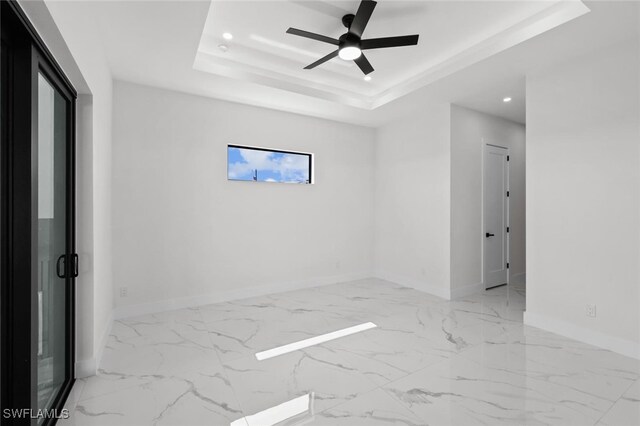 220 NE 6th St, Cape Coral, FL 33909 - spare room with recessed lighting, baseboards, ceiling fan, a tray ceiling, and marble finish flooring
