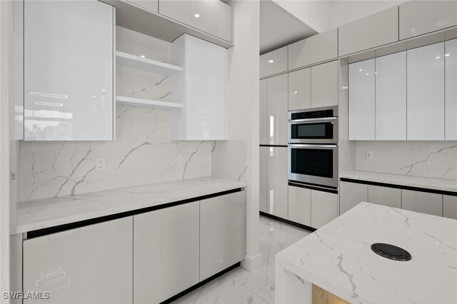 220 NE 6th St, Cape Coral, FL 33909 - kitchen with open shelves, modern cabinets, light marble finish flooring, white cabinets, and backsplash