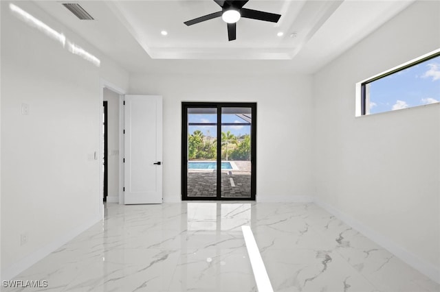 220 NE 6th St, Cape Coral, FL 33909 - spare room with marble tiled flooring, a tray ceiling, baseboards, plenty of natural light, and recessed lighting