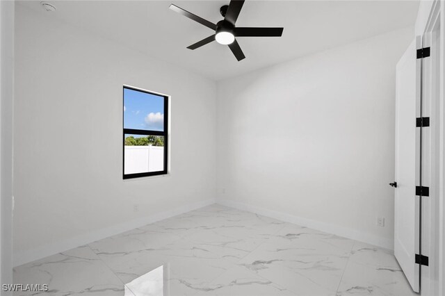 220 NE 6th St, Cape Coral, FL 33909 - spare room featuring baseboards, a ceiling fan, and marble look tile flooring