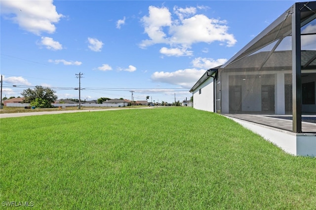 220 NE 6th St, Cape Coral, FL 33909 - view of green lawn with glass enclosure and a patio area
