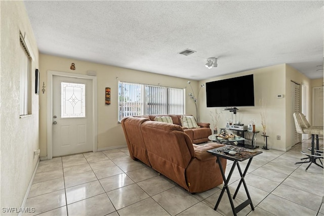 804 Alcala Ave, Lehigh Acres, FL 33936 - living room featuring light tile patterned floors, baseboards, and a textured ceiling