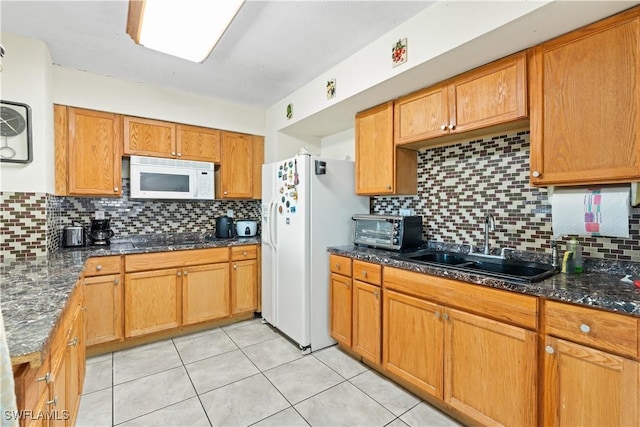 804 Alcala Ave, Lehigh Acres, FL 33936 - kitchen with white appliances, a sink, backsplash, light tile patterned flooring, and dark stone counters