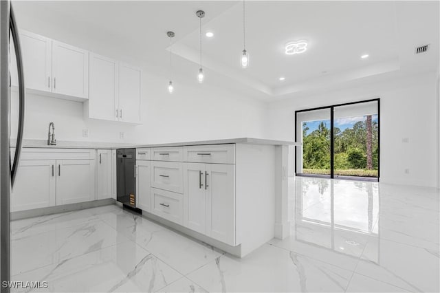 452/454 Loretta Ave S, Lehigh Acres, FL 33974 - kitchen with a tray ceiling, a sink, white cabinets, light marble finish flooring, and light countertops