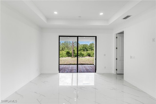 452/454 Loretta Ave S, Lehigh Acres, FL 33974 - unfurnished room featuring a raised ceiling, light marble finish flooring, recessed lighting, and baseboards