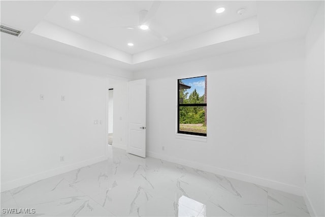 452/454 Loretta Ave S, Lehigh Acres, FL 33974 - unfurnished room featuring baseboards, a tray ceiling, recessed lighting, light marble finish flooring, and ceiling fan