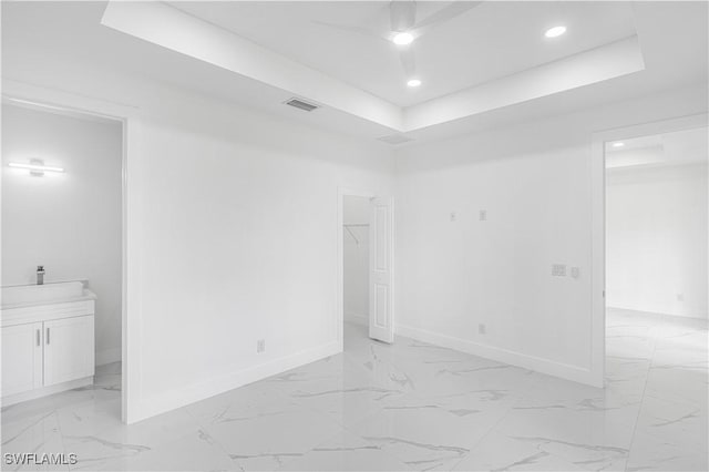 452/454 Loretta Ave S, Lehigh Acres, FL 33974 - empty room with baseboards, a raised ceiling, light marble finish floors, and recessed lighting