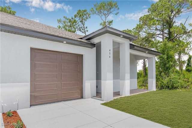 452/454 Loretta Ave S, Lehigh Acres, FL 33974 - view of exterior entry featuring an attached garage, stucco siding, concrete driveway, and a lawn