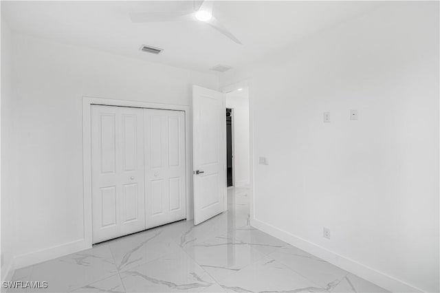 452/454 Loretta Ave S, Lehigh Acres, FL 33974 - unfurnished bedroom featuring baseboards, light marble finish floors, a closet, and a ceiling fan