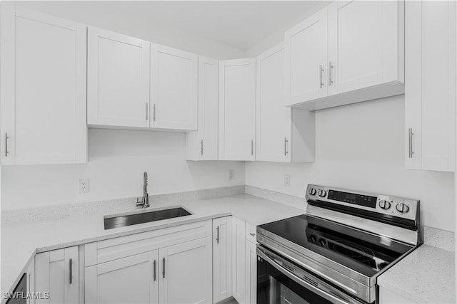 452/454 Loretta Ave S, Lehigh Acres, FL 33974 - kitchen featuring stainless steel electric stove, a sink, and white cabinetry