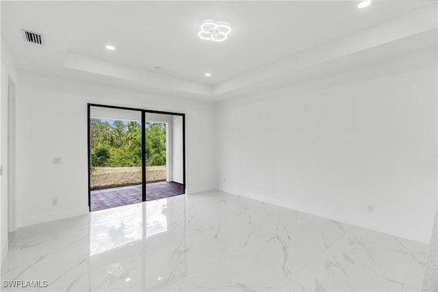 452/454 Loretta Ave S, Lehigh Acres, FL 33974 - empty room with a raised ceiling, light marble finish floors, recessed lighting, and baseboards