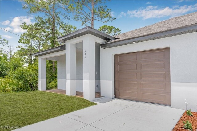 452/454 Loretta Ave S, Lehigh Acres, FL 33974 - view of front of house featuring stucco siding, an attached garage, driveway, and a front lawn