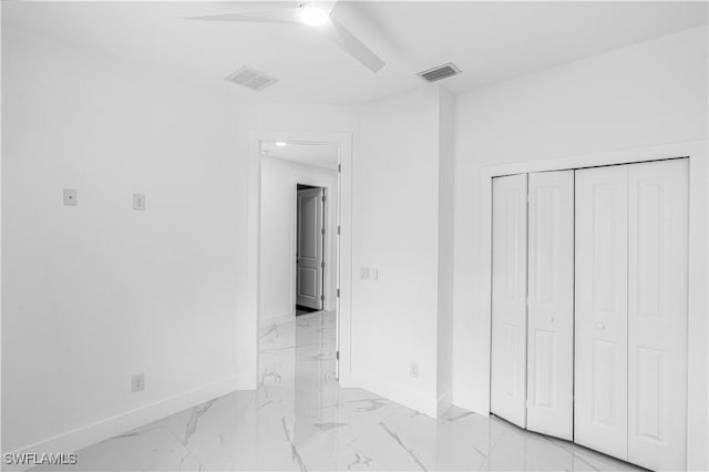 452/454 Loretta Ave S, Lehigh Acres, FL 33974 - unfurnished bedroom featuring baseboards, light marble finish flooring, a closet, and a ceiling fan