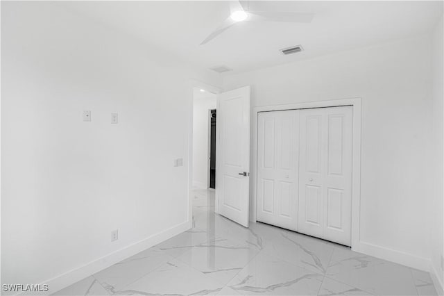 452/454 Loretta Ave S, Lehigh Acres, FL 33974 - unfurnished bedroom featuring baseboards, light marble finish flooring, a closet, and a ceiling fan