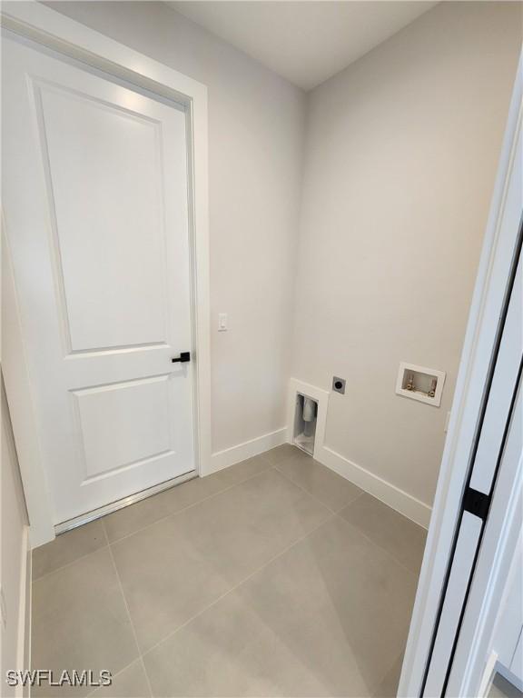 3279 31st Ave NE, Naples, FL 34120 - washroom featuring electric dryer hookup, washer hookup, tile patterned flooring, and baseboards