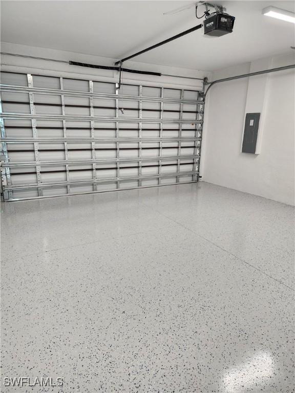 3279 31st Ave NE, Naples, FL 34120 - garage featuring electric panel and a garage door opener