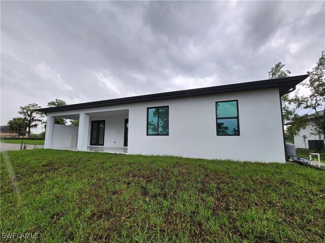 3279 31st Ave NE, Naples, FL 34120 - rear view of property featuring stucco siding and a lawn