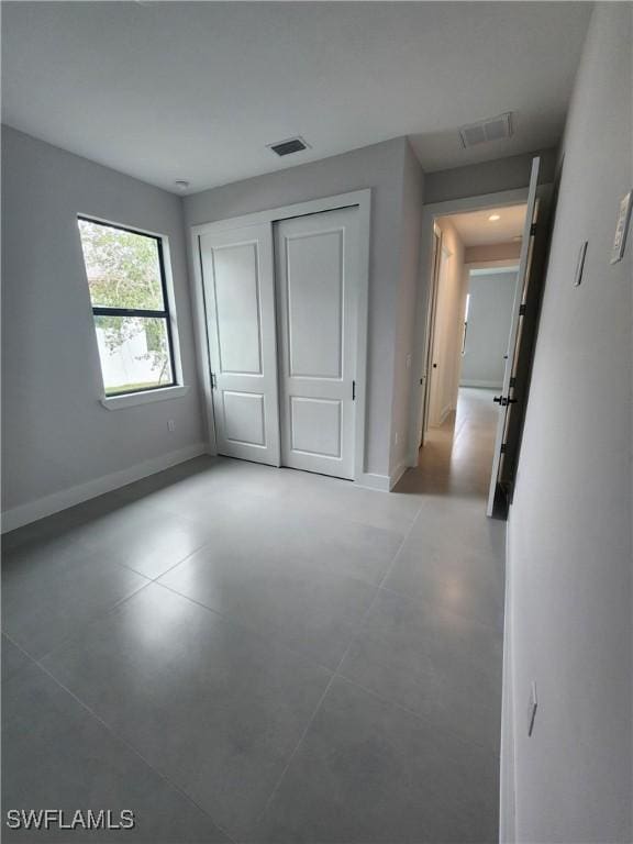 3279 31st Ave NE, Naples, FL 34120 - unfurnished bedroom with baseboards, finished concrete floors, and a closet