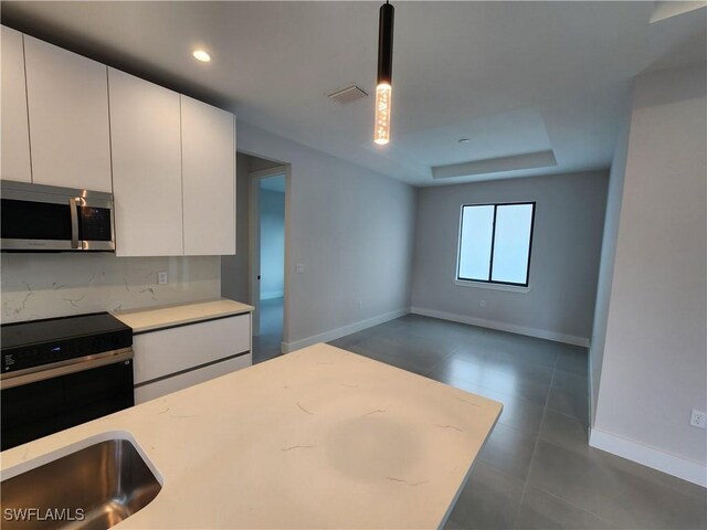 3279 31st Ave NE, Naples, FL 34120 - kitchen with stainless steel appliances, light countertops, baseboards, white cabinets, and recessed lighting