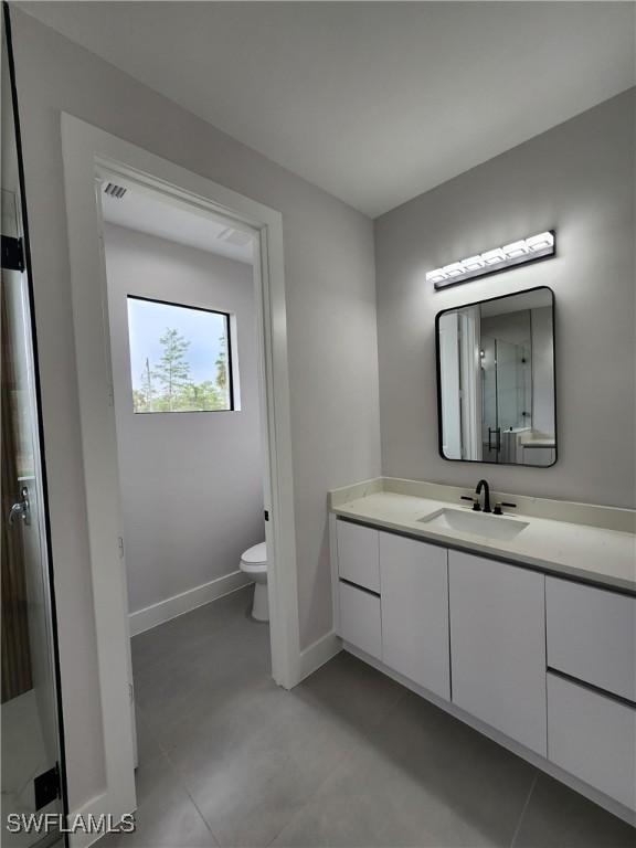 3279 31st Ave NE, Naples, FL 34120 - bathroom with vanity, baseboards, and toilet