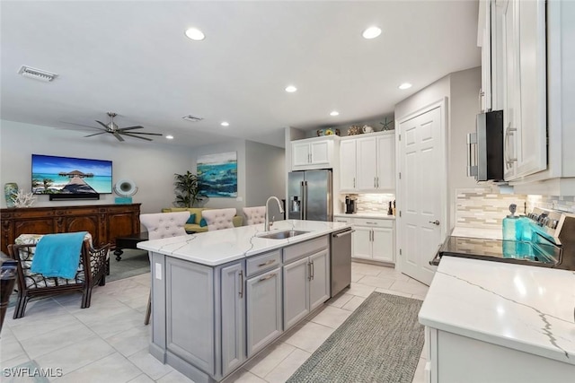 14559 Topsail Dr, Naples, FL 34114 - kitchen featuring appliances with stainless steel finishes, a sink, gray cabinets, tasteful backsplash, and a ceiling fan