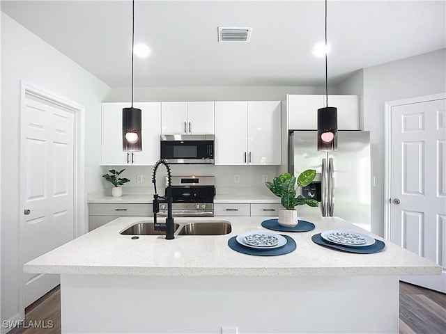 Anthony Anthony Street E 912, Lehigh Acres, FL 33974 - kitchen featuring appliances with stainless steel finishes, white cabinets, a kitchen island with sink, decorative light fixtures, and dark wood-type flooring