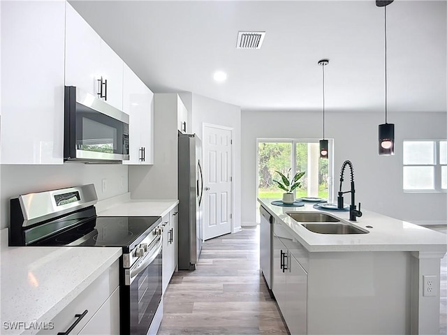 Anthony Anthony Street E 912, Lehigh Acres, FL 33974 - kitchen with stainless steel appliances, modern cabinets, light wood finished floors, a kitchen island with sink, and white cabinets