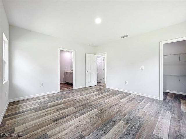 Anthony Anthony Street E 912, Lehigh Acres, FL 33974 - unfurnished bedroom featuring wood finished floors, a walk in closet, a closet, and ensuite bath