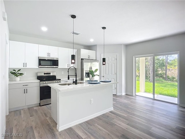 Anthony Anthony Street E 912, Lehigh Acres, FL 33974 - kitchen with stainless steel appliances, light wood-style floors, an island with sink, light countertops, and white cabinets