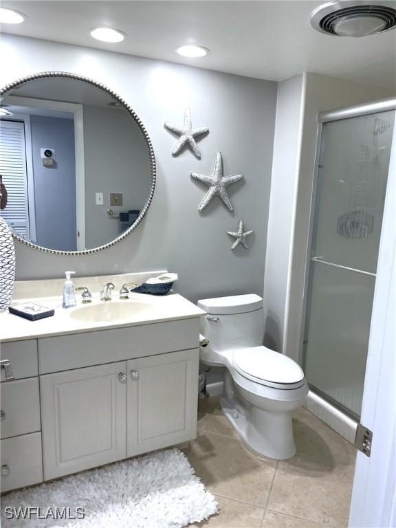 7150 Estero Blvd Unit 800, Fort Myers Beach, FL 33931 - bathroom featuring vanity, a stall shower, toilet, and tile patterned flooring