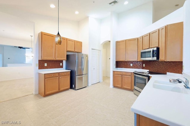 3799 Costa Maya Way Unit 202, Estero, FL 33928 - kitchen featuring stainless steel appliances, a sink, light countertops, arched walkways, and pendant lighting