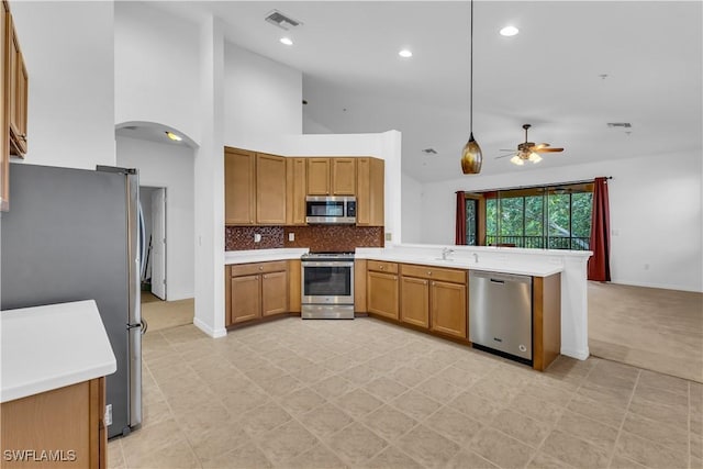 3799 Costa Maya Way Unit 202, Estero, FL 33928 - kitchen with stainless steel appliances, ceiling fan, a peninsula, a sink, and arched walkways