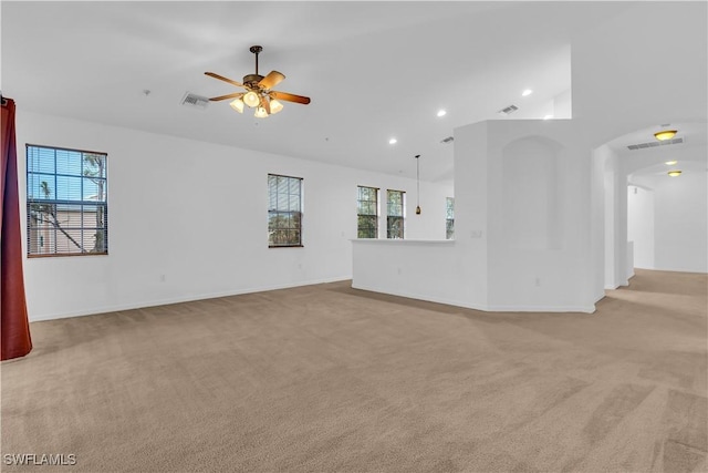 3799 Costa Maya Way Unit 202, Estero, FL 33928 - unfurnished living room featuring light carpet, plenty of natural light, a ceiling fan, recessed lighting, and arched walkways