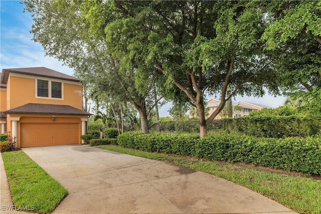 3799 Costa Maya Way Unit 202, Estero, FL 33928 - view of front of property with stucco siding, an attached garage, and concrete driveway