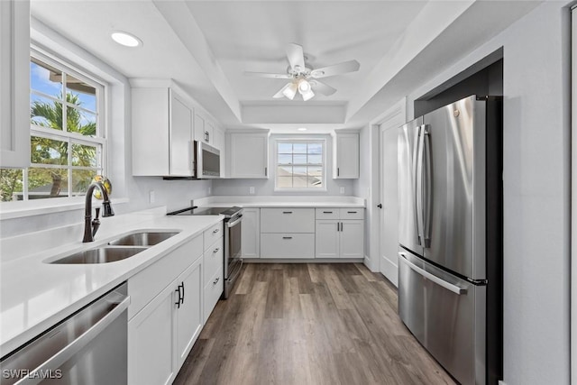 3061 Shell Mound Blvd, Fort Myers Beach, FL 33931 - kitchen featuring stainless steel appliances, a sink, a tray ceiling, ceiling fan, and white cabinets
