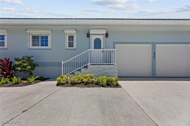 3061 Shell Mound Blvd, Fort Myers Beach, FL 33931 - view of front of home with driveway, an attached garage, and stucco siding