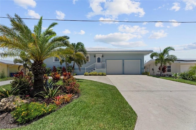 3061 Shell Mound Blvd, Fort Myers Beach, FL 33931 - view of front of house with stucco siding, an attached garage, a front yard, and concrete driveway