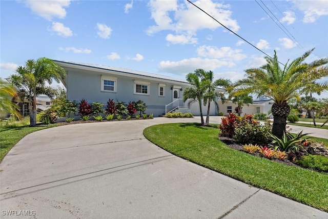 3061 Shell Mound Blvd, Fort Myers Beach, FL 33931 - ranch-style home with curved driveway, stucco siding, and a front lawn