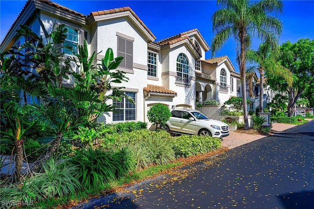133 Colonade Cir, Naples, FL 34103 - mediterranean / spanish house with a tile roof, stucco siding, and driveway