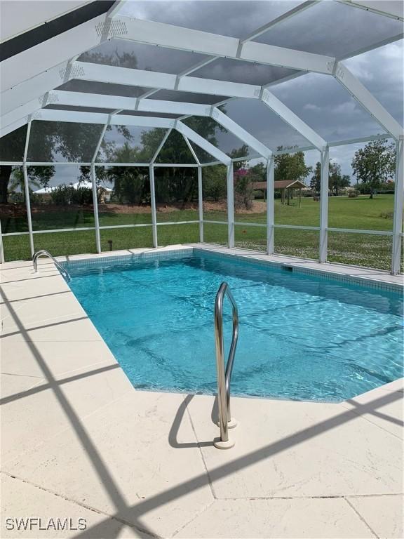 1118 Grove Dr, Naples, FL 34120 - swimming pool with a lawn, a lanai, and a patio