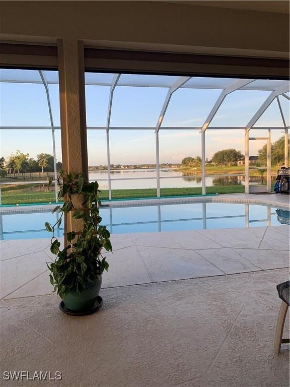 1118 Grove Dr, Naples, FL 34120 - pool at dusk with an outdoor pool, a lanai, a patio area, and a water view