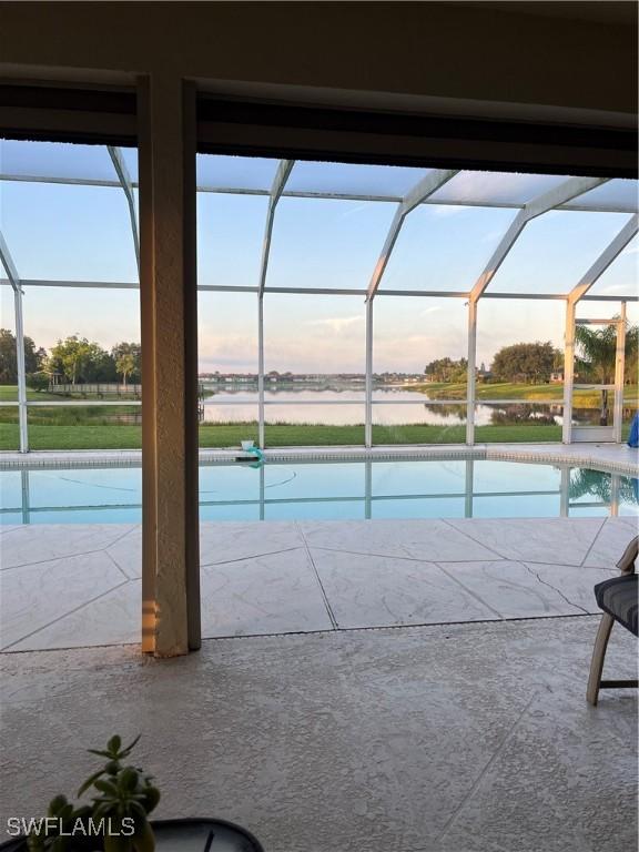 1118 Grove Dr, Naples, FL 34120 - outdoor pool with glass enclosure, a water view, and a patio area