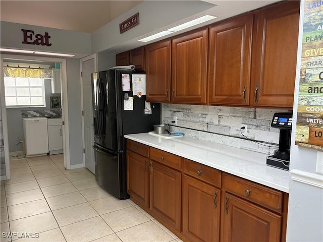 1118 Grove Dr, Naples, FL 34120 - kitchen featuring freestanding refrigerator, light tile patterned floors, backsplash, light countertops, and brown cabinets
