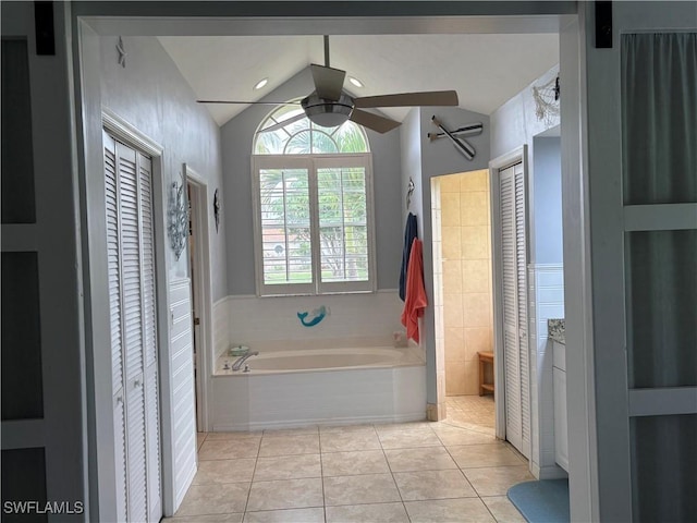 1118 Grove Dr, Naples, FL 34120 - bathroom featuring a closet, ceiling fan, tiled tub, lofted ceiling, and tile patterned floors