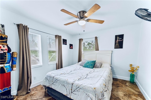 2011 Mill St, Lehigh Acres, FL 33972 - bedroom featuring stone finish floors, baseboards, and ceiling fan
