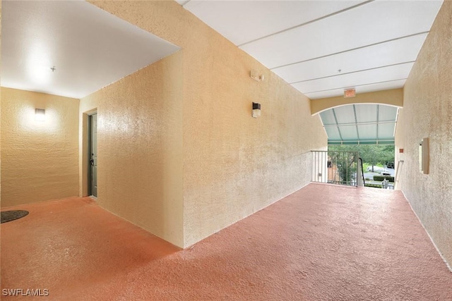 1205 Wildwood Lakes Blvd Unit 305, Naples, FL 34104 - hall featuring a textured wall and arched walkways