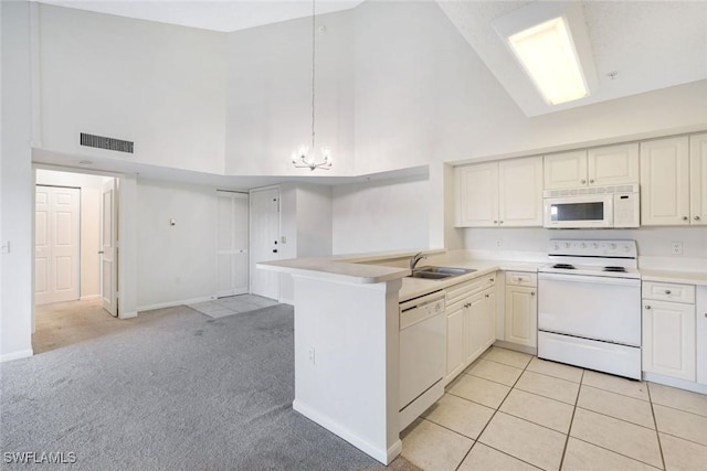 1205 Wildwood Lakes Blvd Unit 305, Naples, FL 34104 - kitchen with white appliances, high vaulted ceiling, a peninsula, light countertops, and light colored carpet